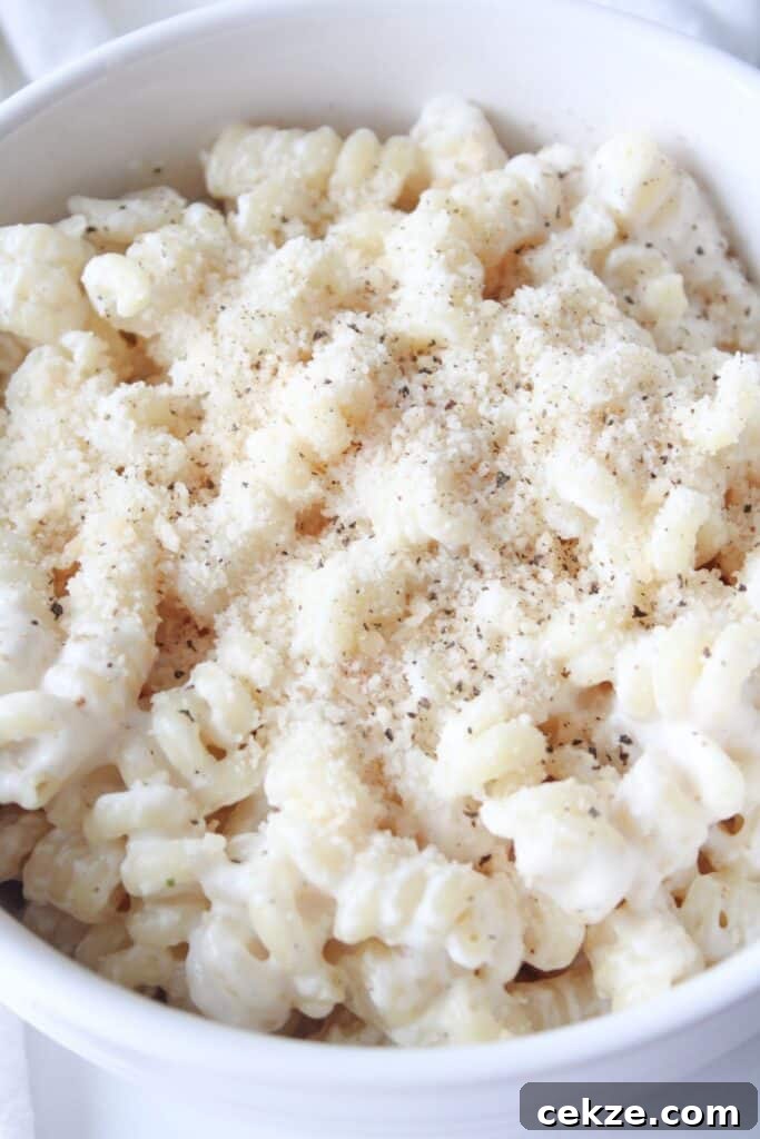A bowl full of cottage cheese pasta sauce on chickpea pasta and topped with parmesan cheese and black pepper.