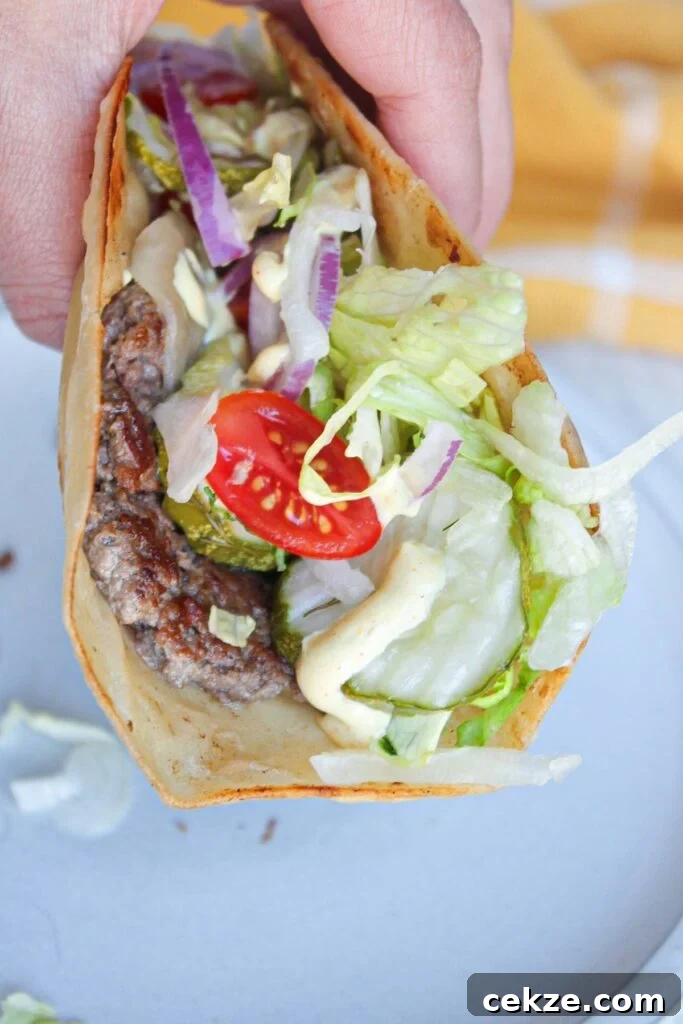 A smash burger taco with burger toppings and burger sauce.