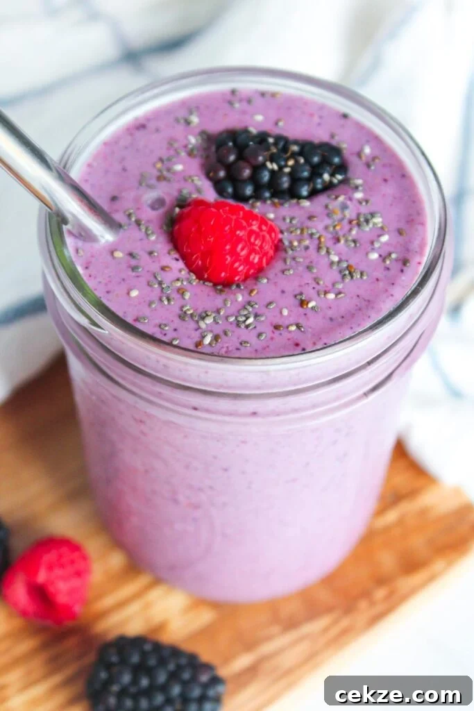 A high fiber smoothie with mixed berries, chia seeds and banana sprinkled with chia seeds and berries on top.