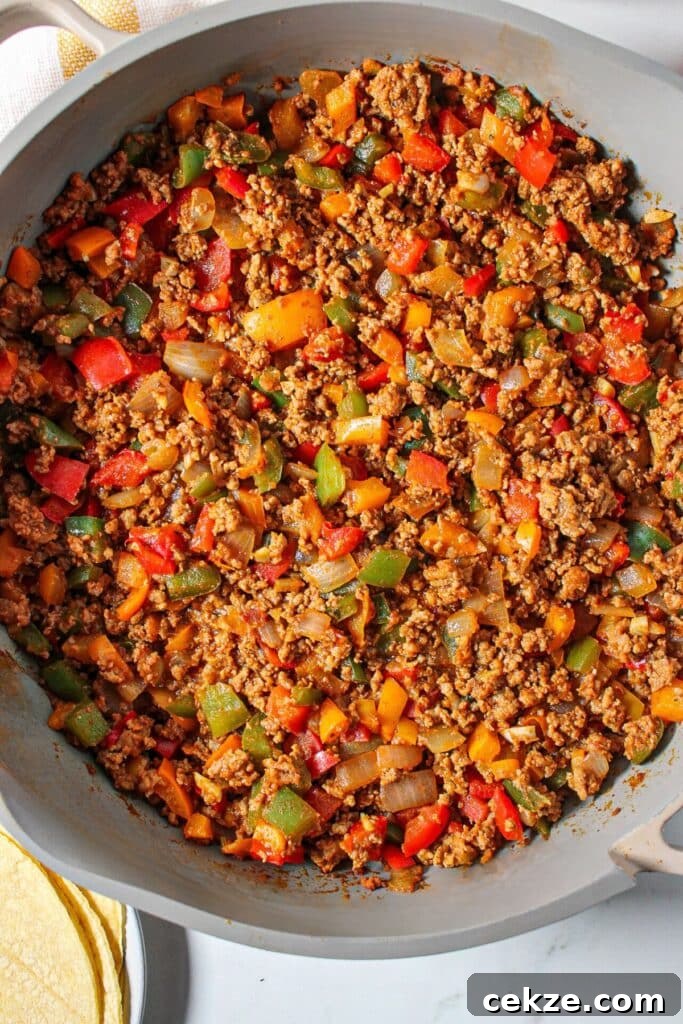 Taco meat with peppers in a skillet.