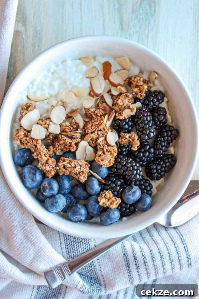 Cottage cheese, granola and berries in a bowl with a spoon.