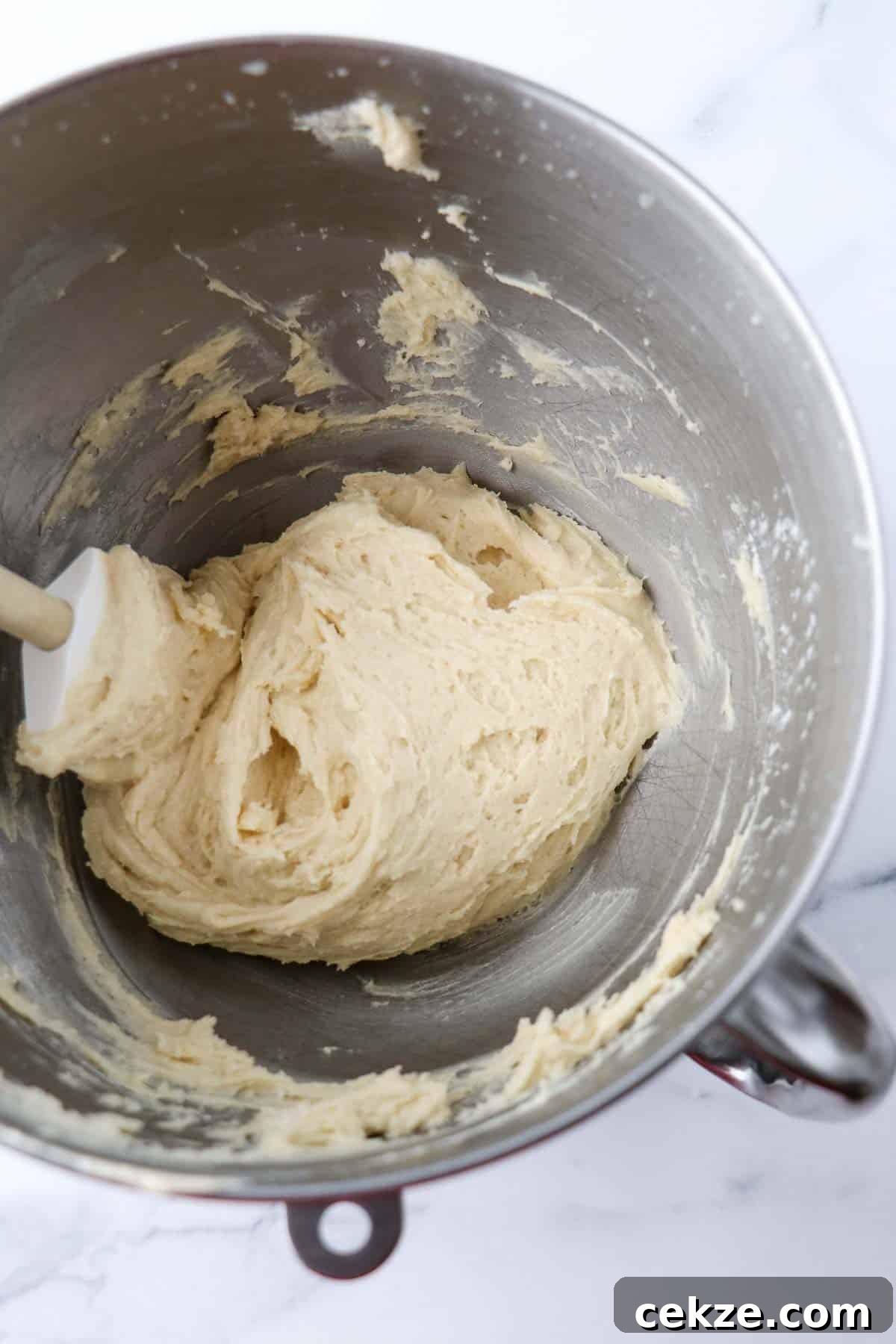 Old-Fashioned Buttermilk Cookie Dough in a metal bowl with a rubber spatula.