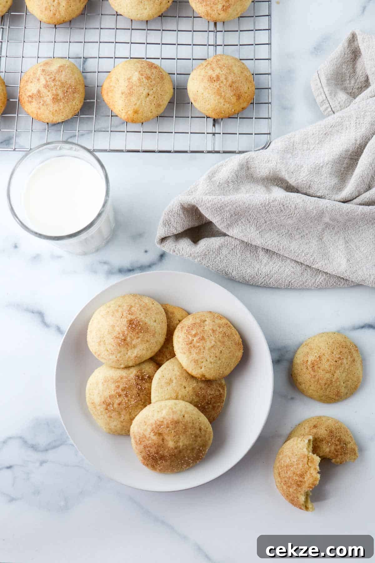 Overhead view of Old-Fashioned Buttermilk Cookies on a plate next to a glass of milk.