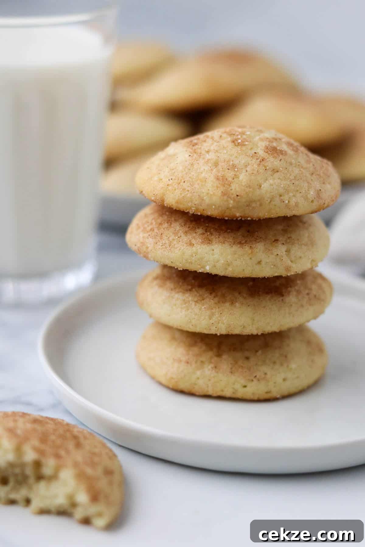 Stack of buttermilk cookies next to a glass of milk.