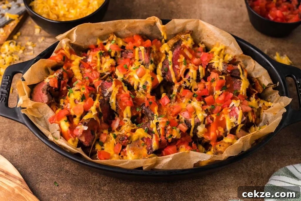 A casserole dish with steak loaded fries.