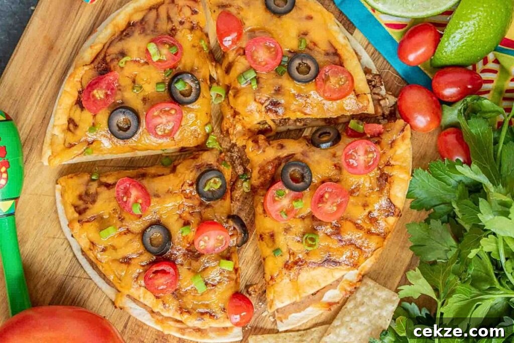 A Mexican pizza topped with tomatoes and olives, cut into quarters.