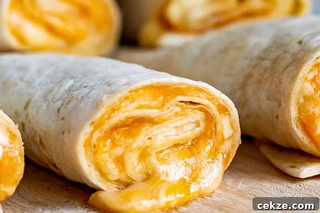 A plate of roll ups, filled with melty cheese.