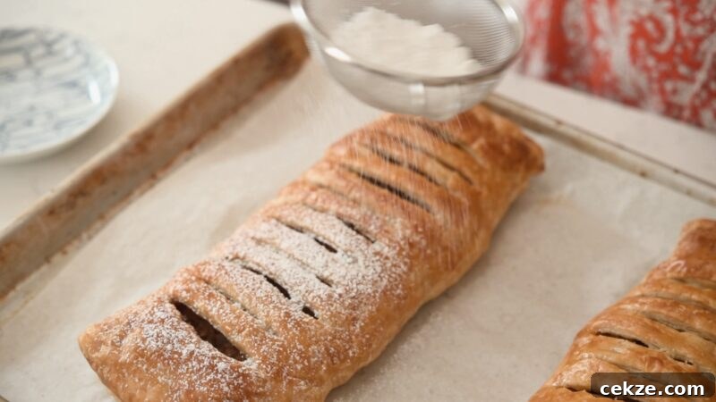 Dusting powdered sugar over warm, freshly baked apple strudel
