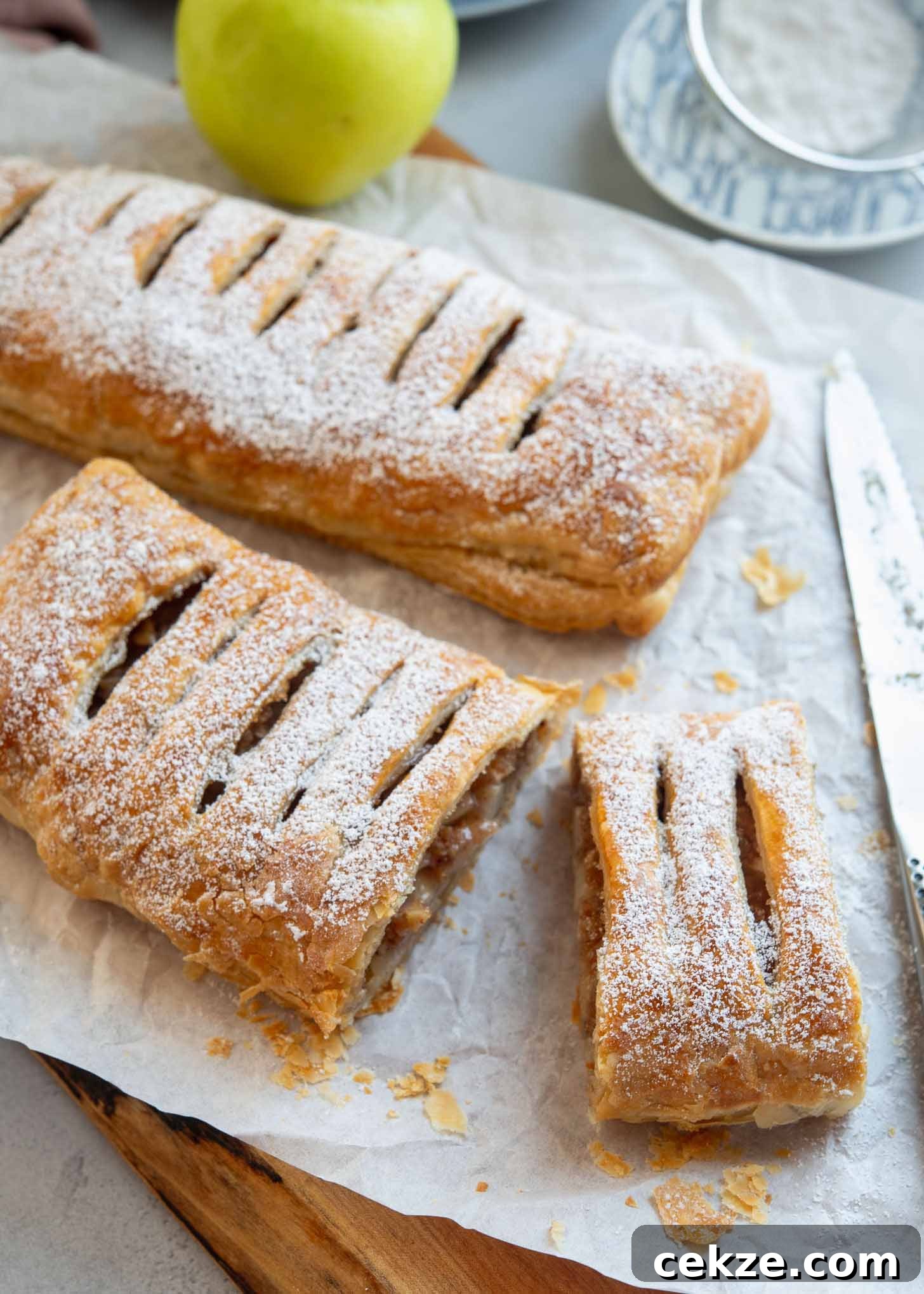 Puff pastry apple strudel dusted with powdered sugar and sliced.