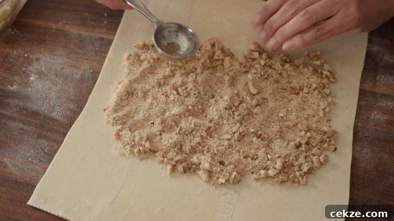 Spreading breadcrumb and walnut mixture over puff pastry sheet