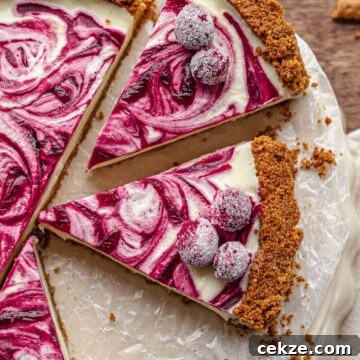 Slices of white chocolate tart topped with sugared cranberries on a serving platter.