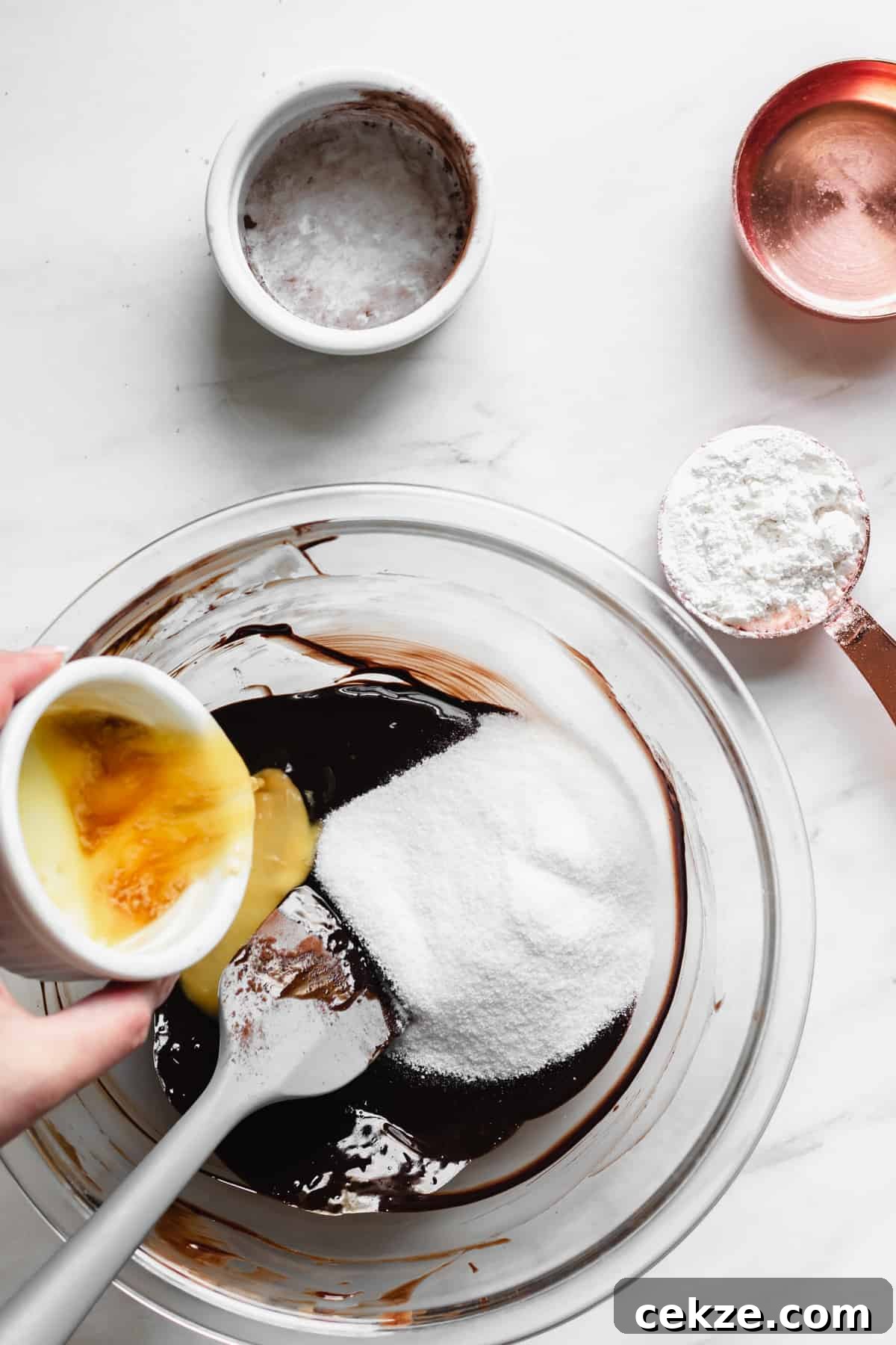 Whisked eggs being added to brownie batter