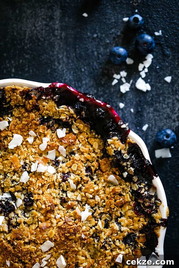 It takes just 15 minutes to prepare this delicious Coconut Blueberry Crisp featuring warm, bubbly blueberries capped by a crunchy cap of oats and coconut. The oat topping of a Coconut Blueberry Crisp.