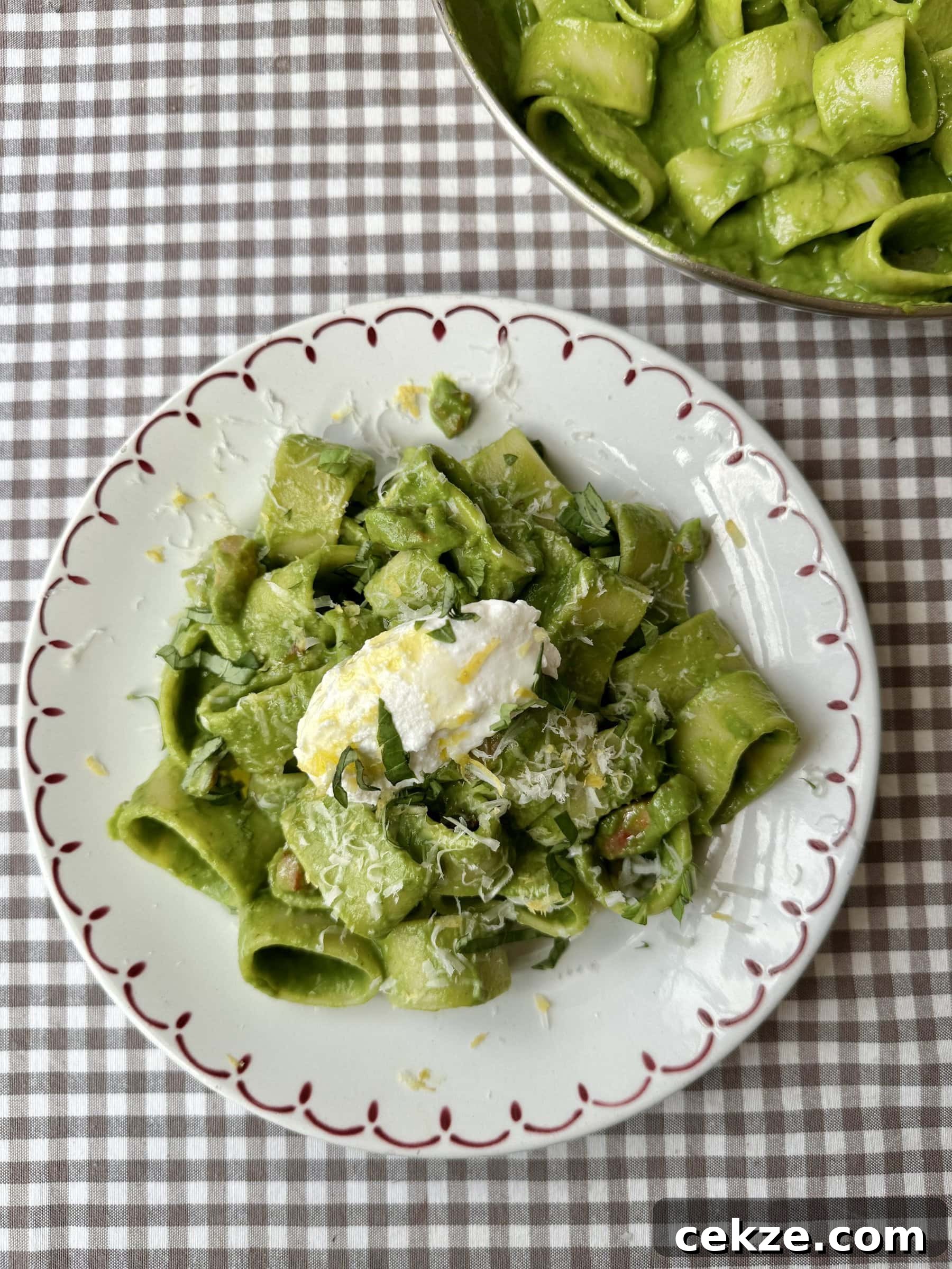 Creamy Spinach Pesto Pasta with Garlic and Lemon 3 pasta in green sauce on a plate topped with cheese