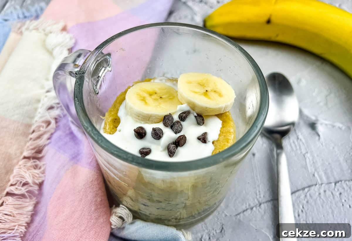 Banana chocolate mug cake with spoon and banana.