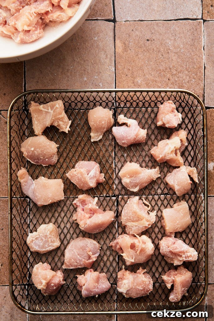raw chicken arranged on an air fryer tray ready to cook 