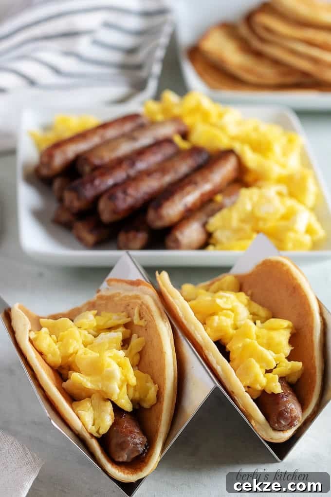 Two breakfast tacos, sitting on metal holders, ready to be served.