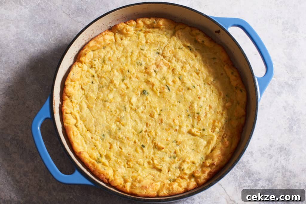 Baked jalapeño spoonbread in a blue casserole pan.