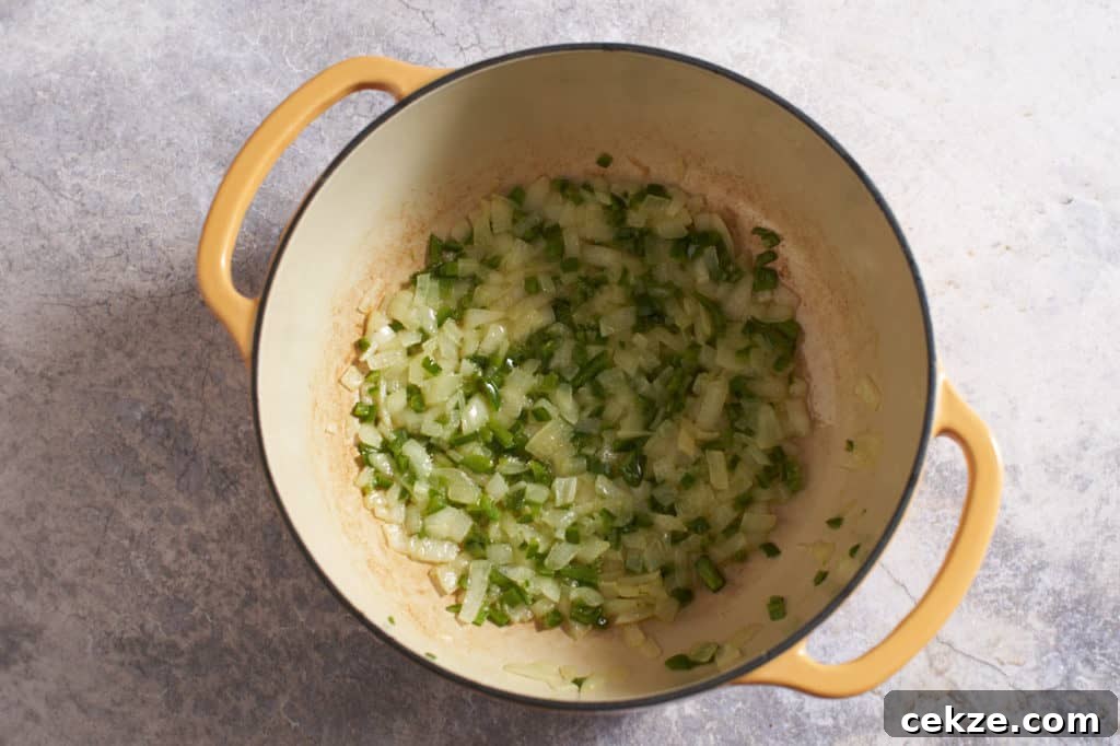 A dutch oven with sautéed onions and jalapeños.