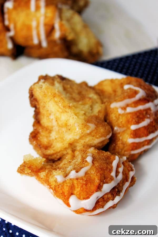 a piece of cinnamon sugar monkey bread pulled apart from the loaf on the plate