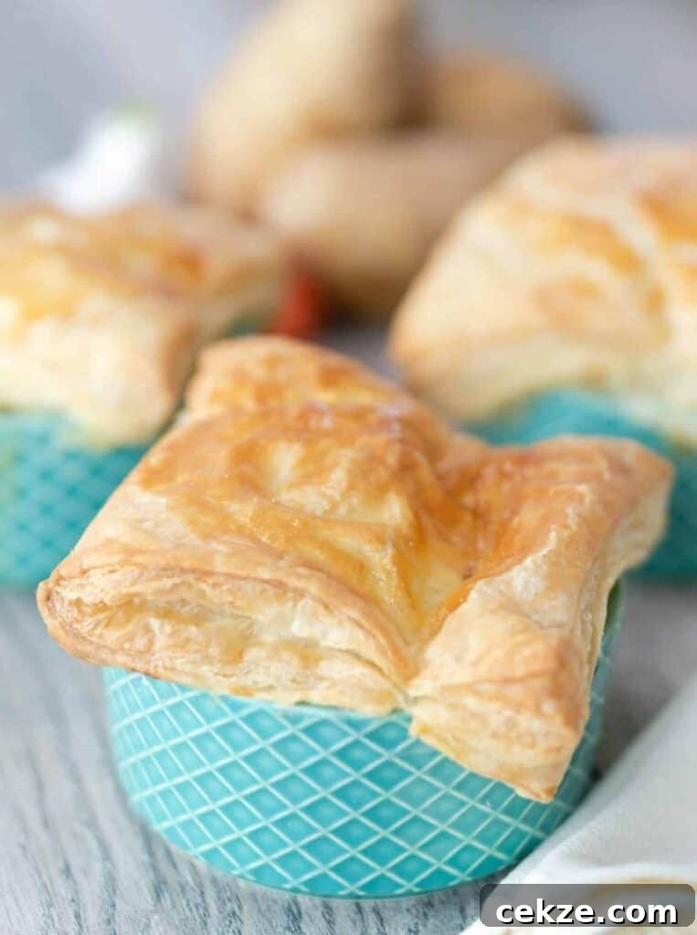 Flaky puff pastry square sitting on top of a ramekin of Chicken Pot Pie.