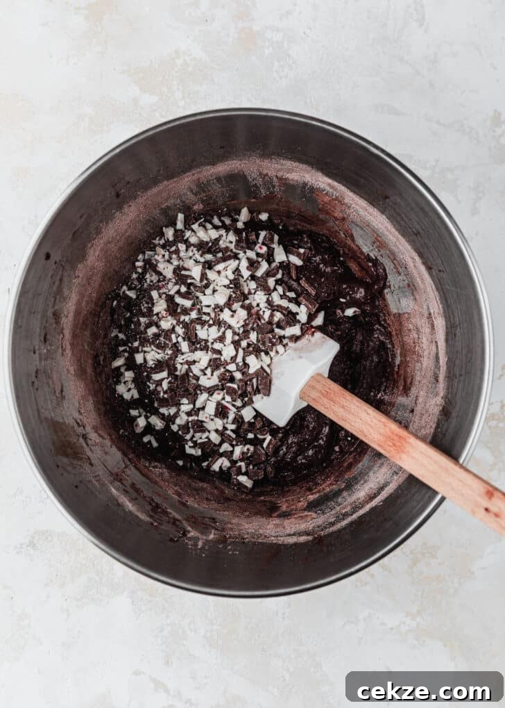 A silver bowl of dough for mini chocolate peppermint bark cookies.