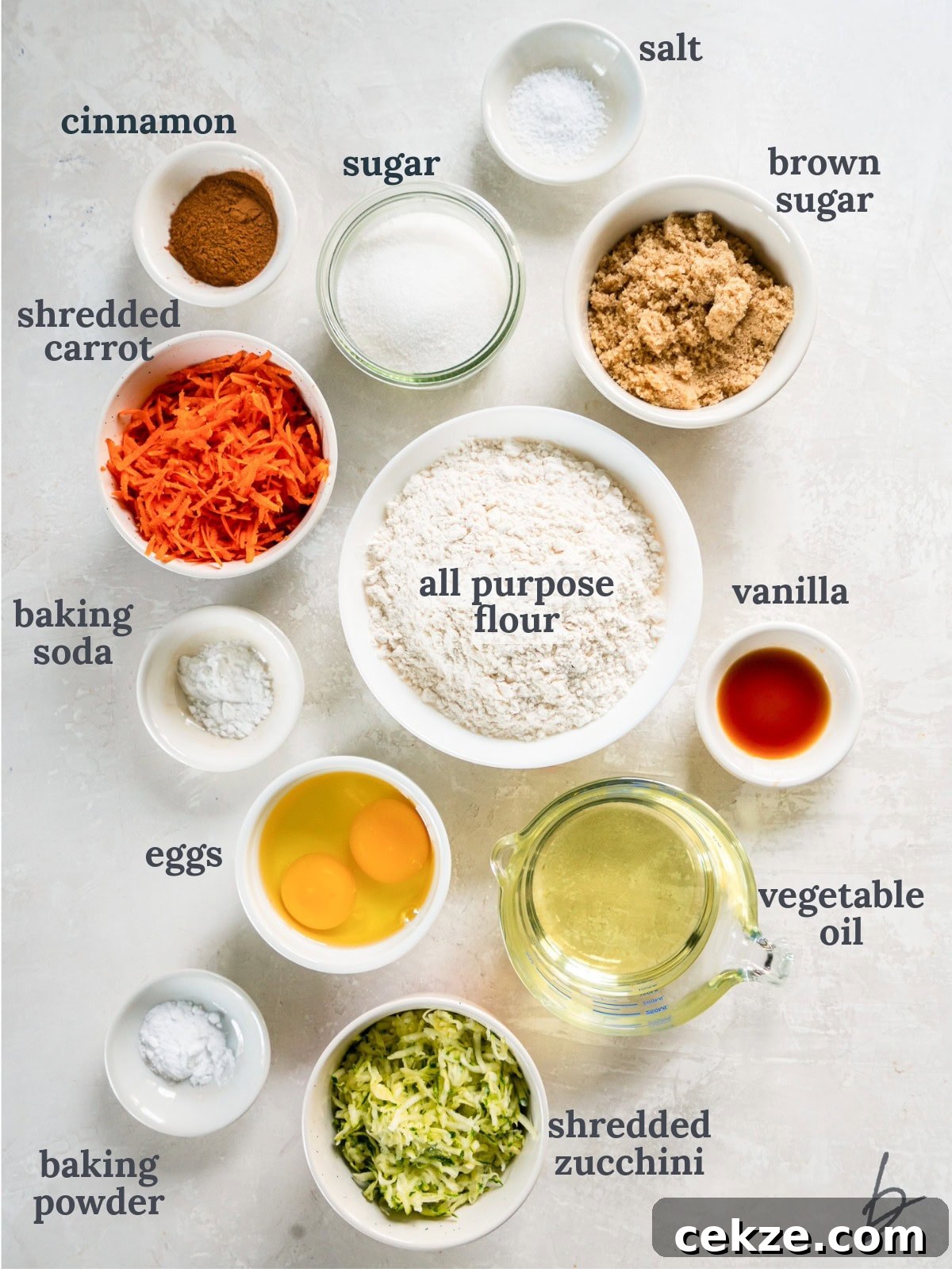 tabletop with bowls of ingredients to make zucchini carrot bread.