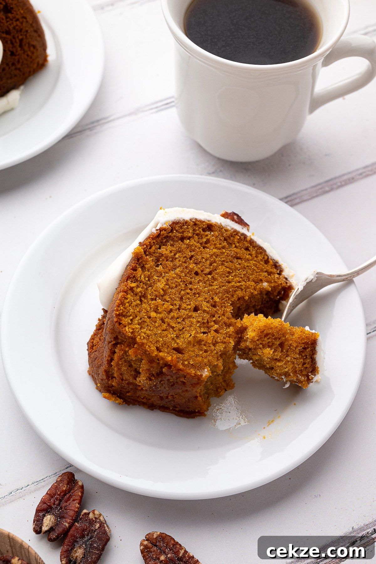 slice of cake on dessert plate served with cup of black coffee