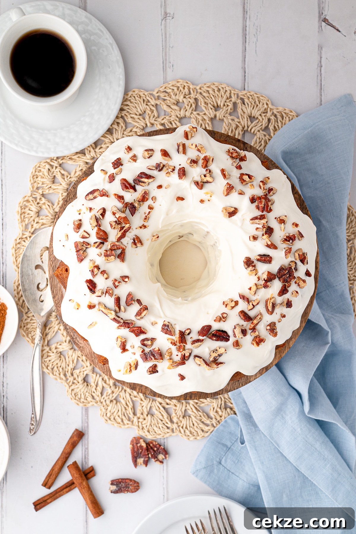 pecans topping cream cheese frosting on pumpkin cake