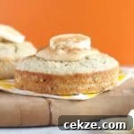 Cake with peanut butter and a banana on top with an orange background.
